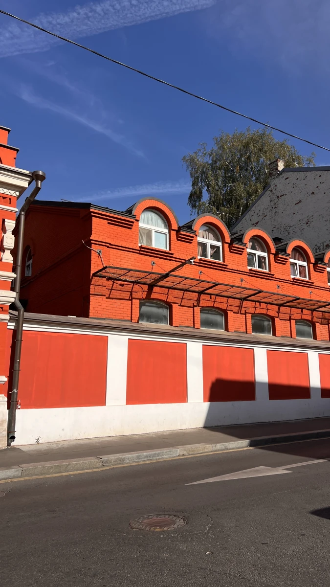 Яркий красно-оранжевый фасад с полукруглыми элементами
