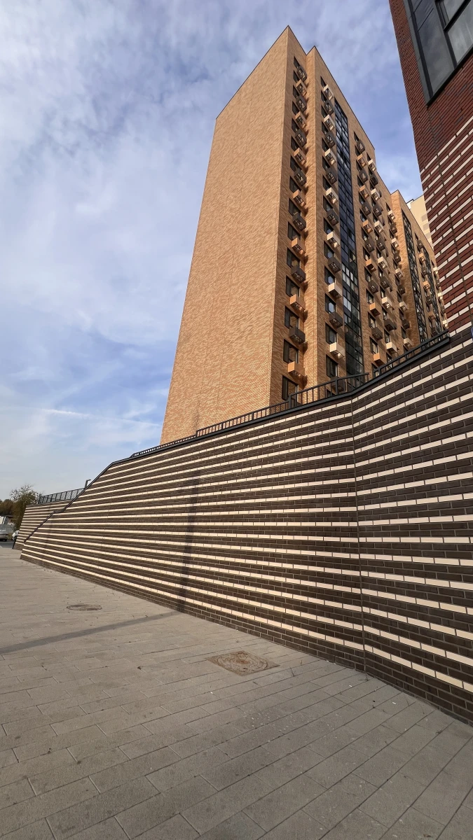 Высокая лестница с кирпичной стеной на фоне