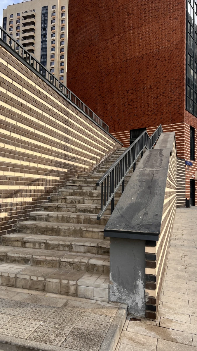 Высокая лестница с кирпичной стеной на фоне