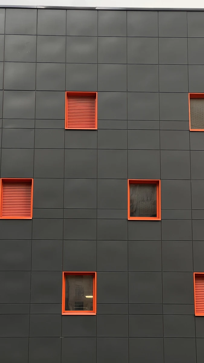 Черный фасад с яркими оранжевыми окнами