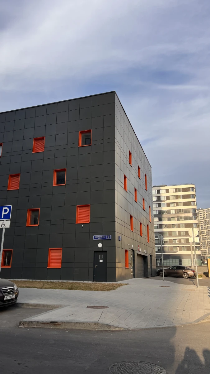 Черный фасад с яркими оранжевыми окнами