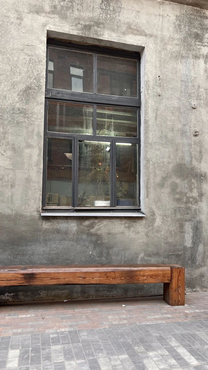 Деревянная скамейка на фоне бетонной стены