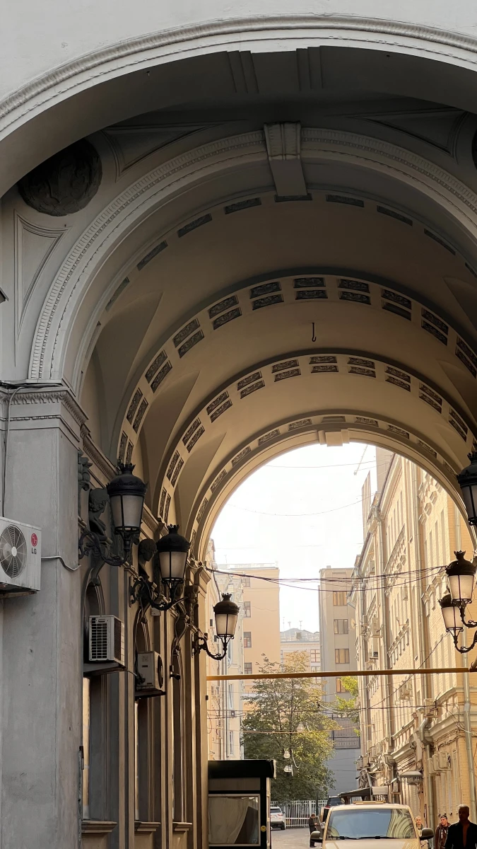 Монументальная арка здания со старинными фонарями внутри