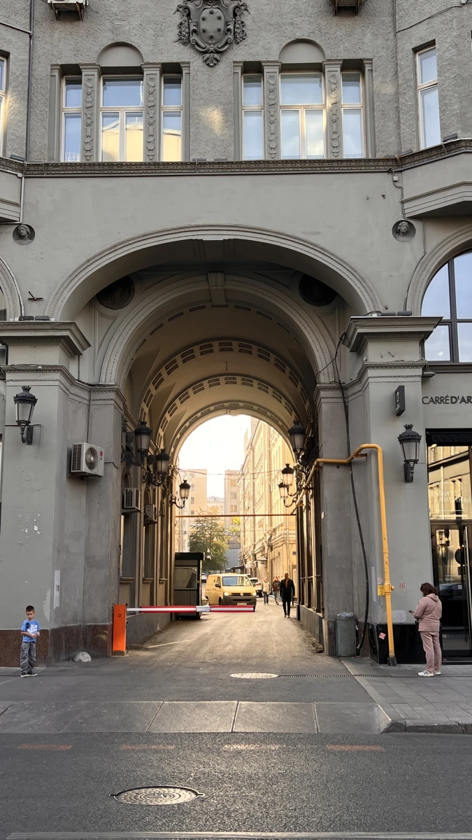 Монументальная арка здания со старинными фонарями внутри