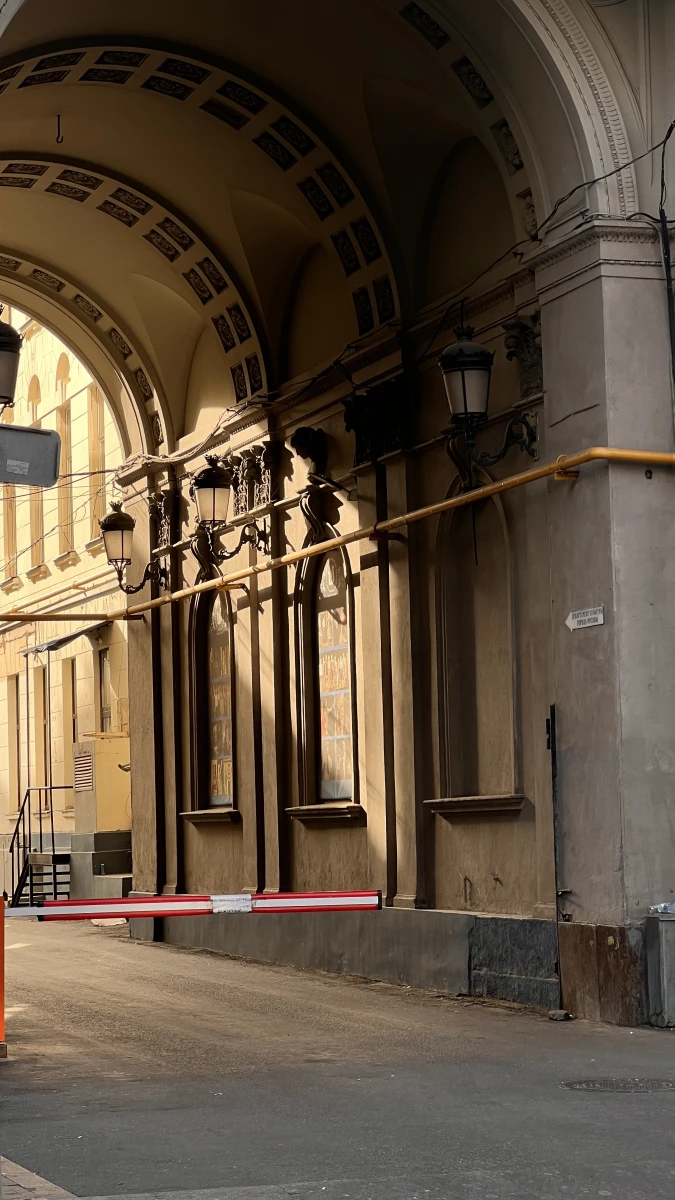 Монументальная арка здания со старинными фонарями внутри