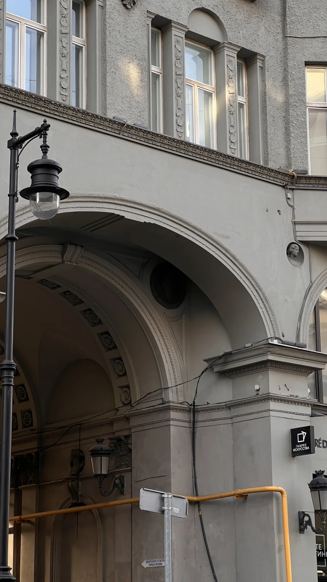 Монументальная арка здания со старинными фонарями внутри