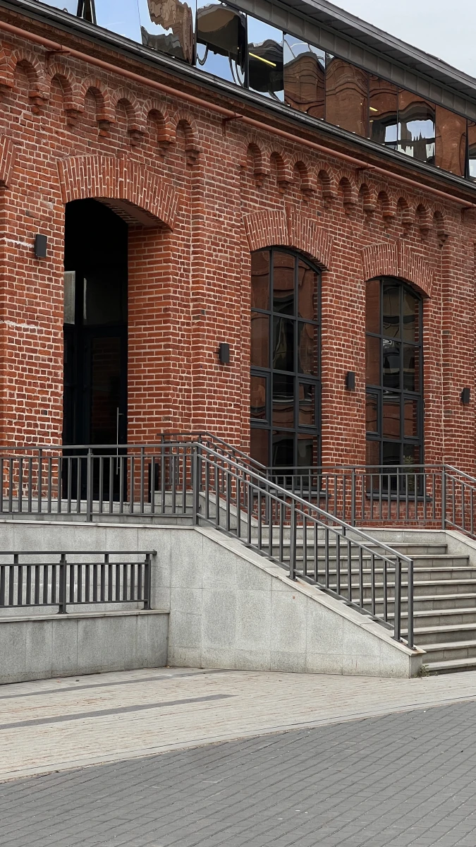 Красивая лестница на фоне фасада из красного кирпича