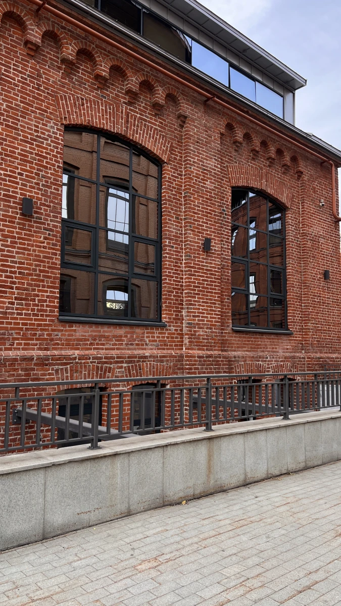 Красивая лестница на фоне фасада из красного кирпича