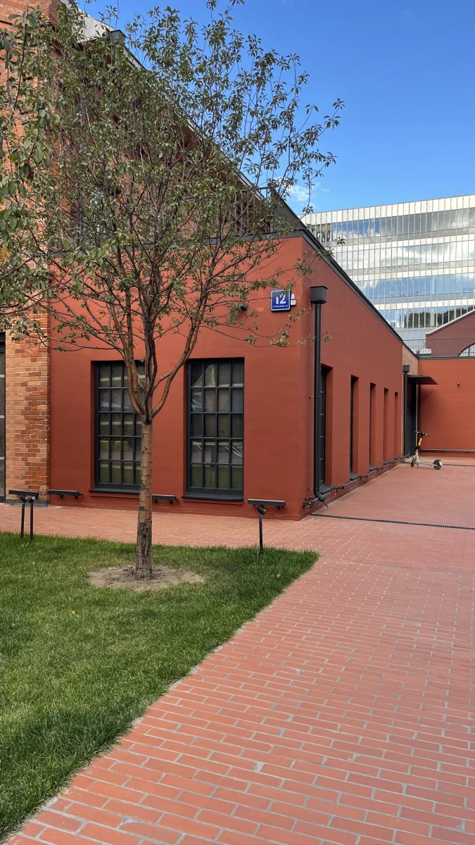 Здание кирпичного цвета c черным остеклением