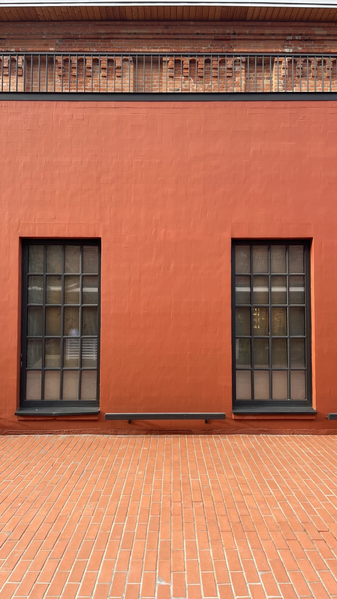 Здание кирпичного цвета c черным остеклением