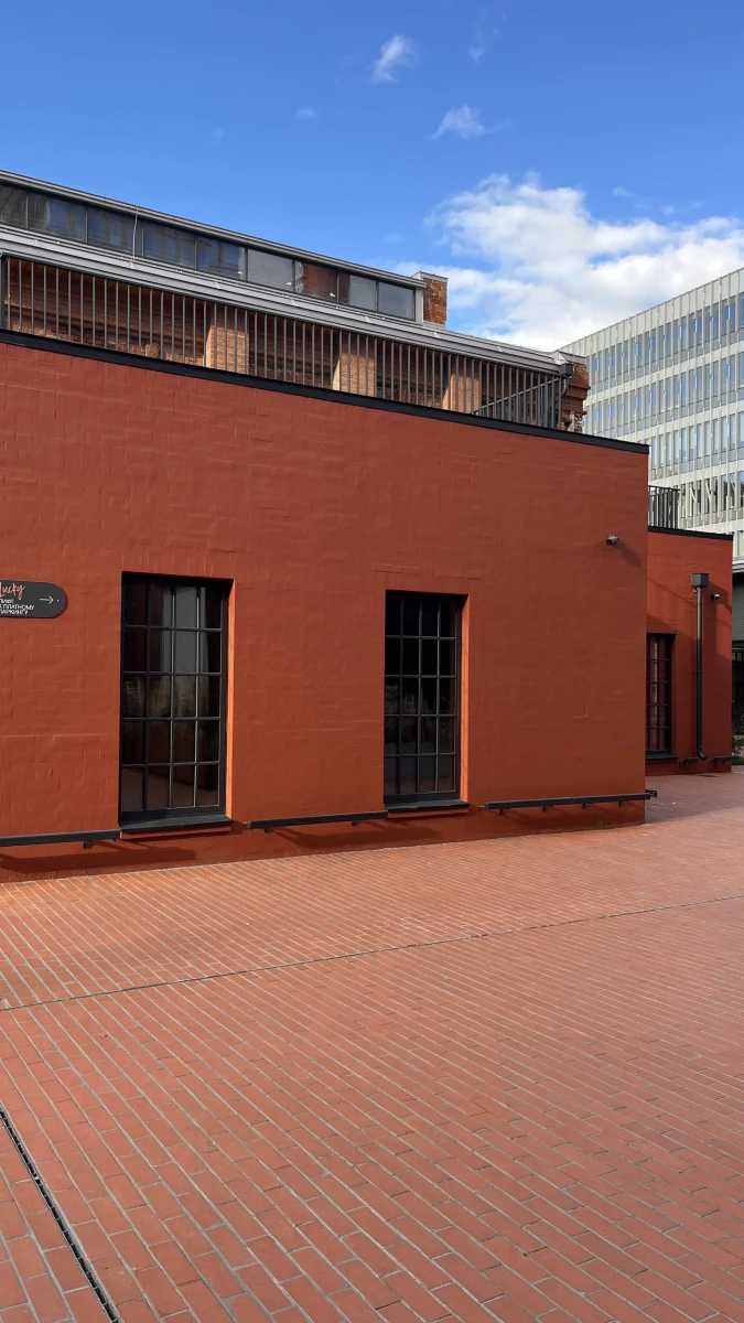 Здание кирпичного цвета c черным остеклением