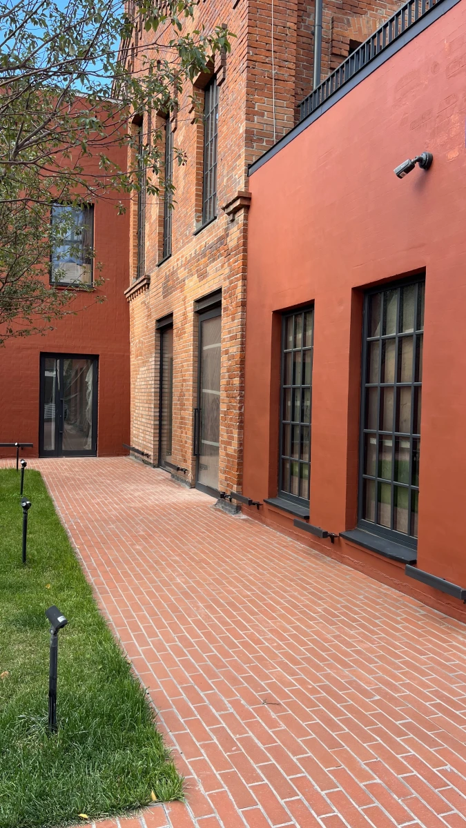 Здание кирпичного цвета c черным остеклением