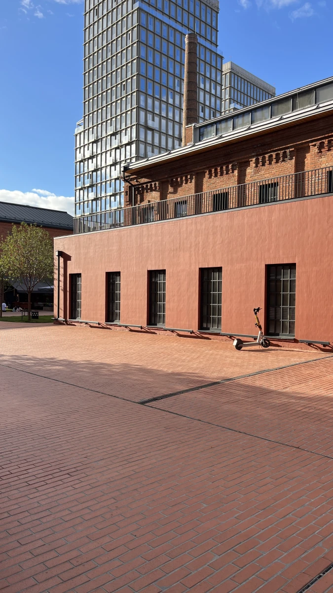 Здание кирпичного цвета c черным остеклением