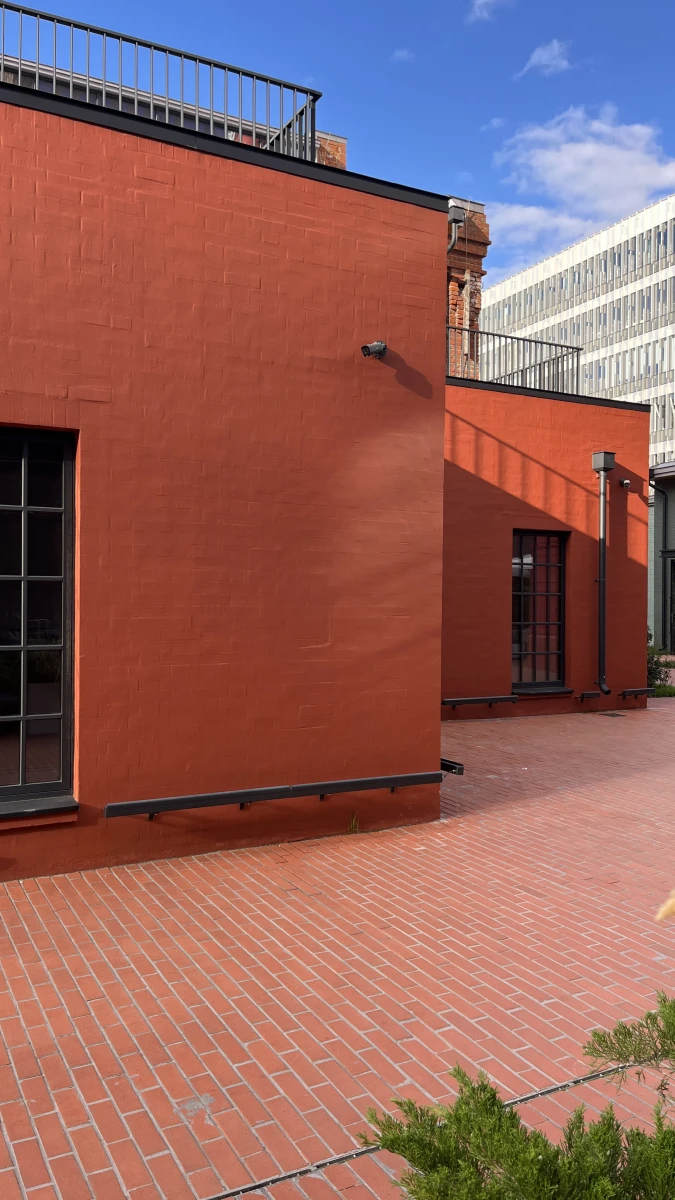 Здание кирпичного цвета c черным остеклением