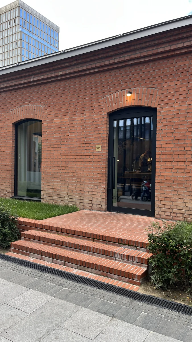 Красное кирпичное здание, трубы и лестница