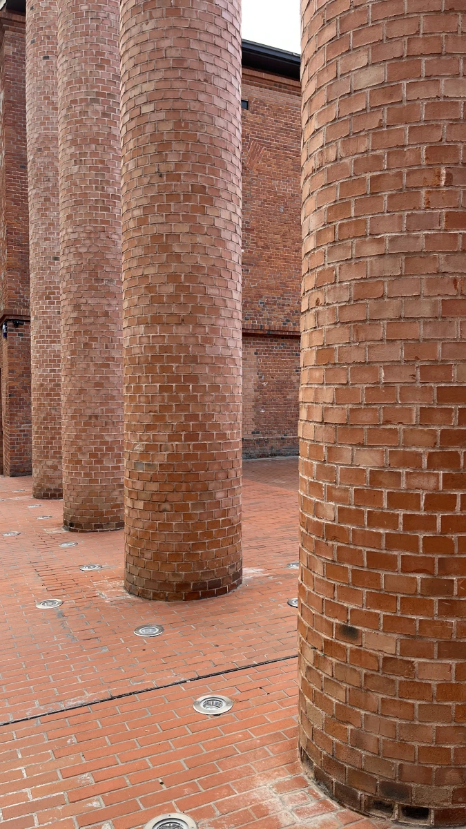 Красное кирпичное здание, трубы и лестница