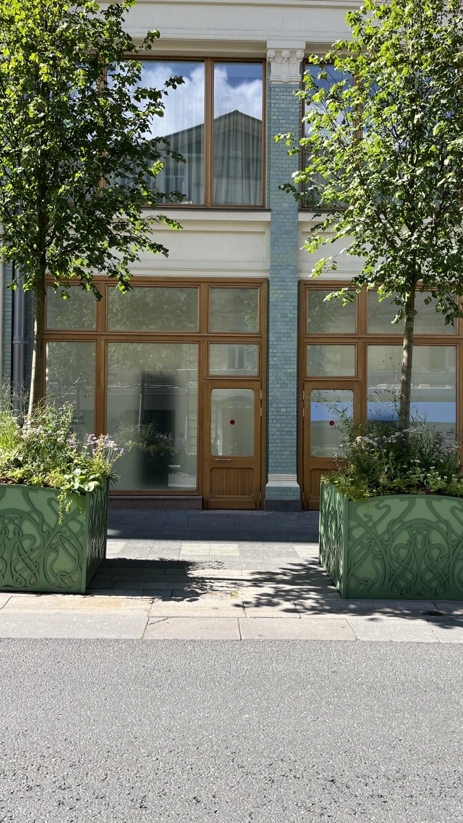 Фасад с мятного цвета плиткой и деревянными дверьми