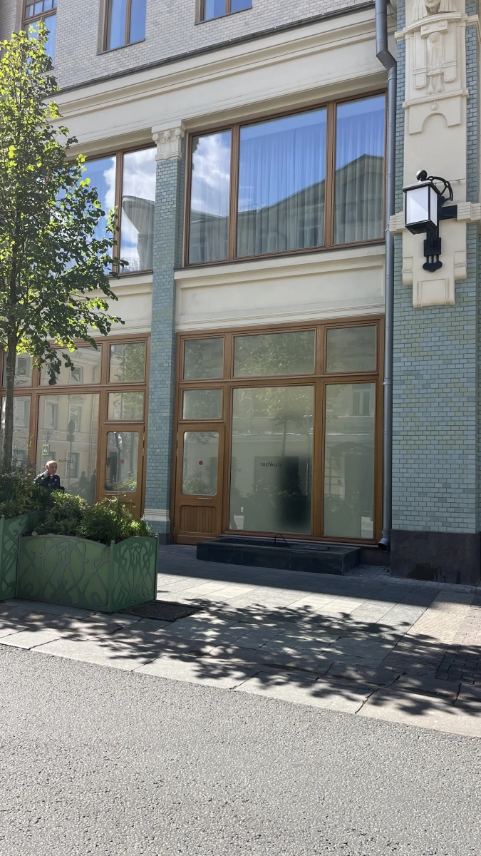 Фасад с мятного цвета плиткой и деревянными дверьми