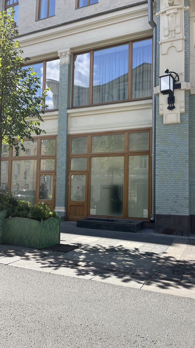 Фасад с мятного цвета плиткой и деревянными дверьми