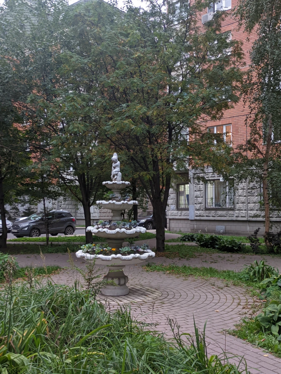 Уютный дворик с качелями и скульптурой-фонтаном