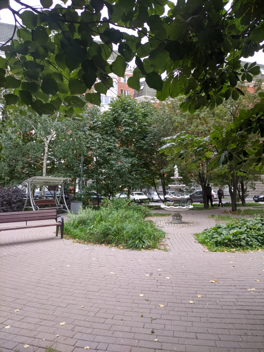 Уютный дворик с качелями и скульптурой-фонтаном