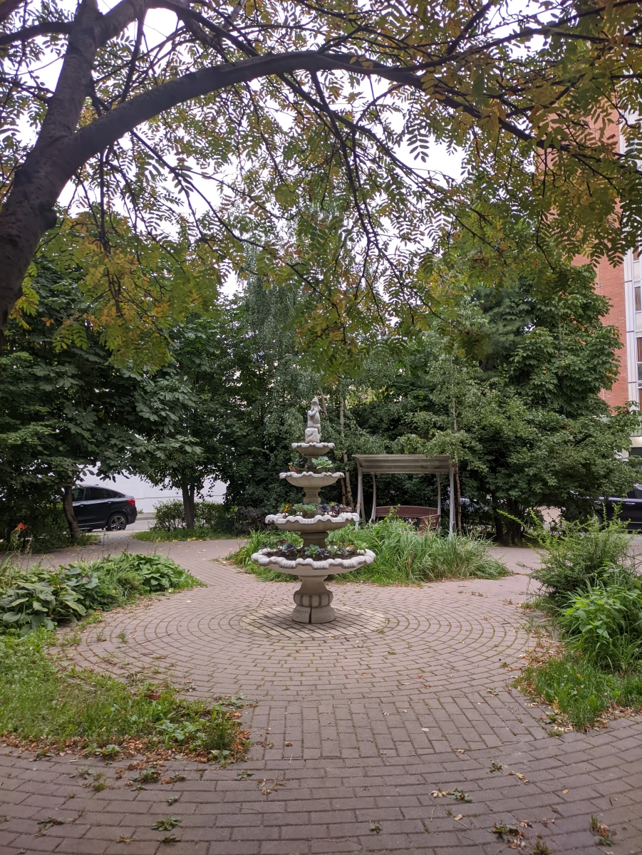 Уютный дворик с качелями и скульптурой-фонтаном