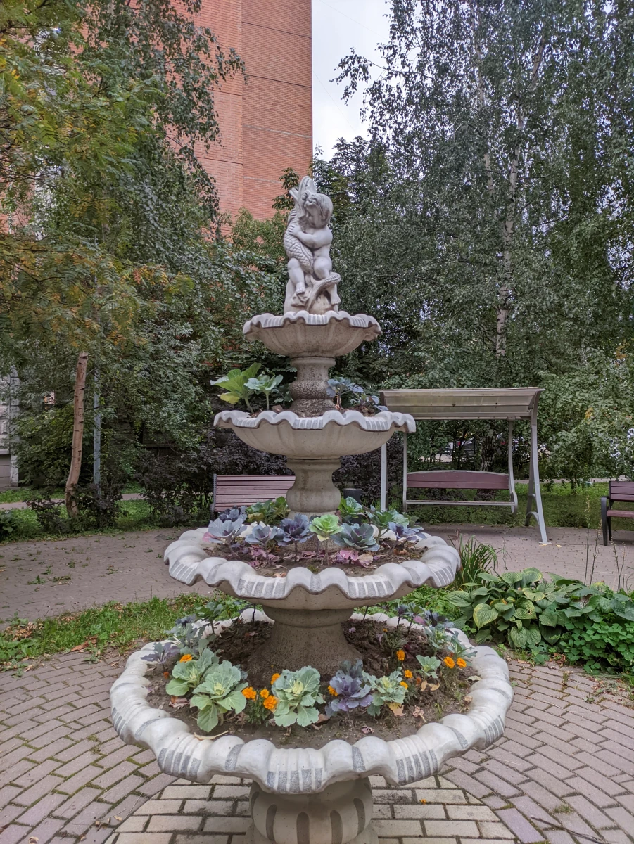 Уютный дворик с качелями и скульптурой-фонтаном