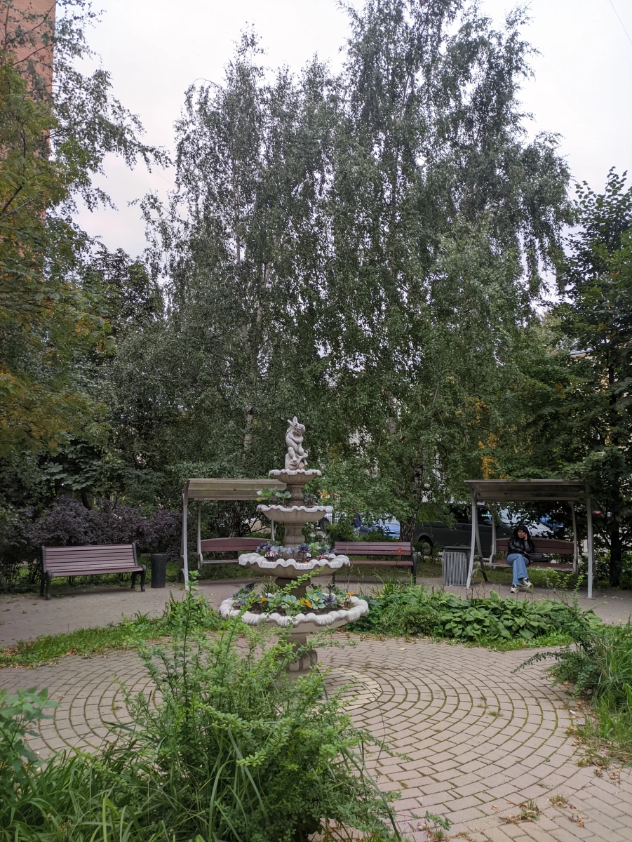 Уютный дворик с качелями и скульптурой-фонтаном